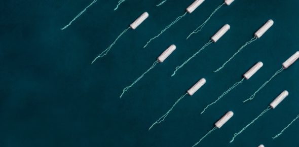 Two diagonal rows of unwrapped tampons sit on a black background.